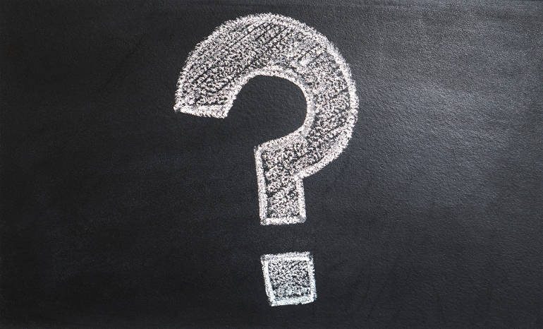 White question mark on black chalk board.
