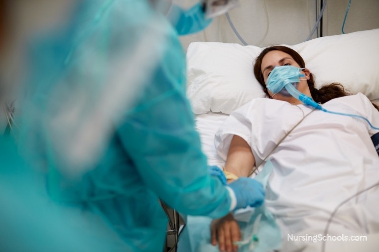 Critical Care Nurse administering IV medication to a patient in the Intensive Care Unit (ICU).