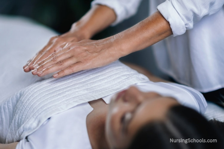 Holistic Nurse using Reiki energy healing techniques on a patient.