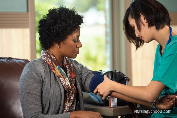 Home Health Nurse checks a patient's blood pressure and heart rate at home.