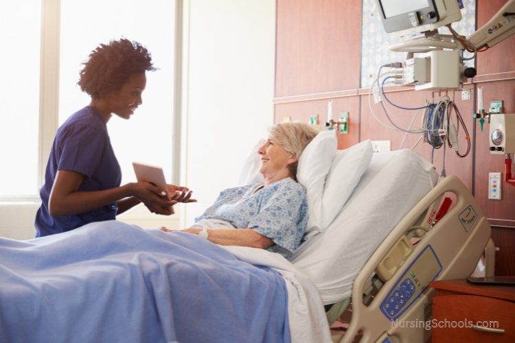Hospice Nurse documents care while talking to a patient.