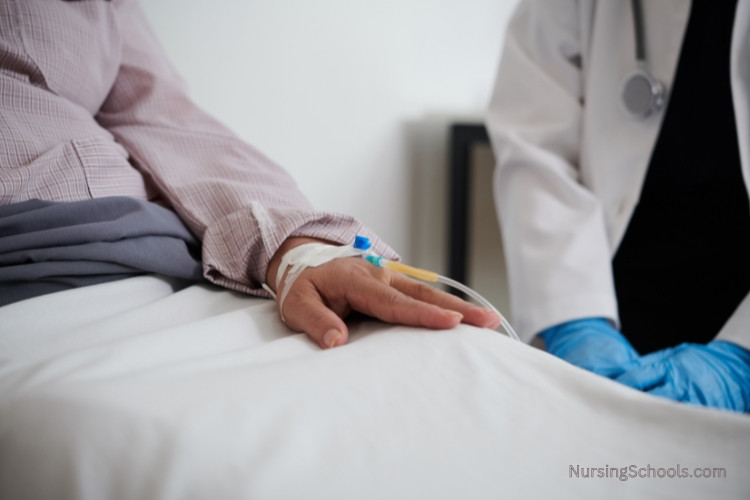 Infusion Nurse observing a patient while checking her catheter.