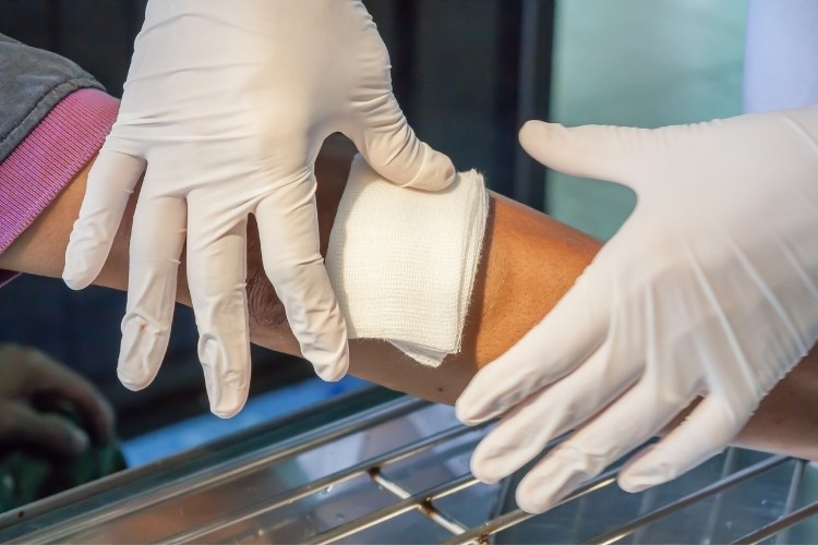 Vocational Nurse (VN) cleans and dresses a wound as part of her job duties.