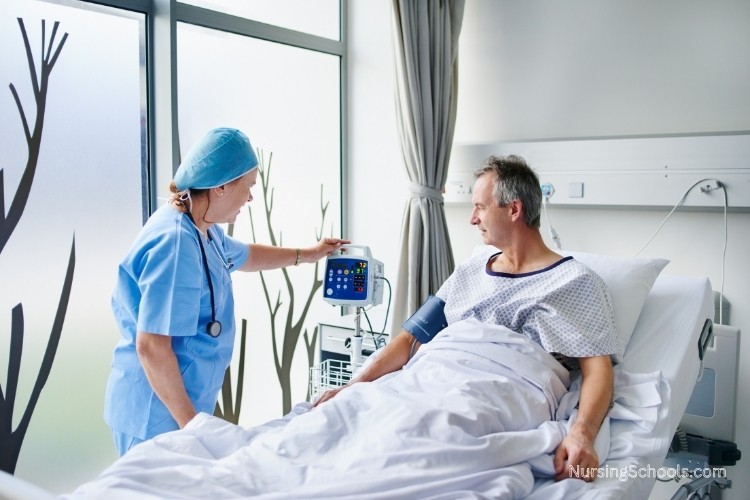 Neuroscience Nurse monitors a patient sitting in a hospital bed.