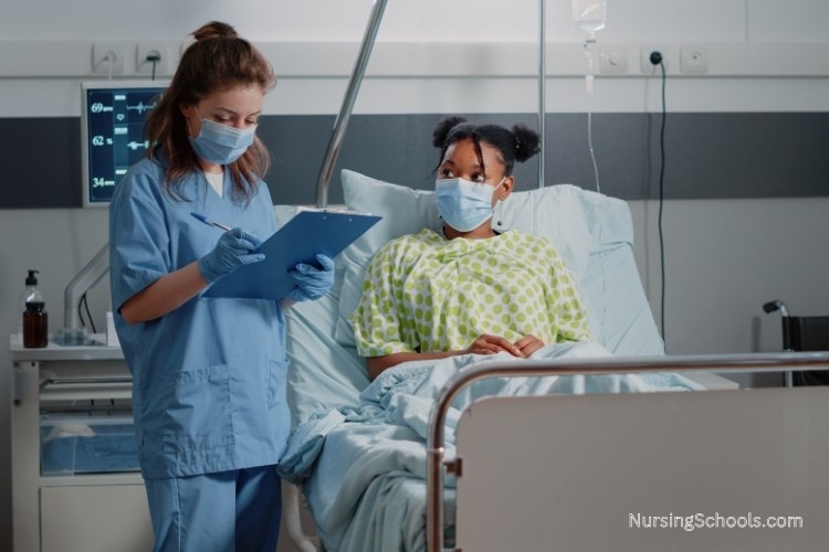 Nurse Advocate reviews care details with a patient in a hospital bed.