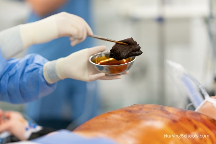 Preoperative Nurse sterilizes the surgical site on a patient in the operating room.