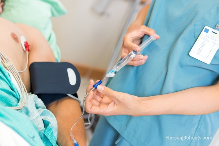 Preoperative Nurse administers medication to a patient through an intravenous line.