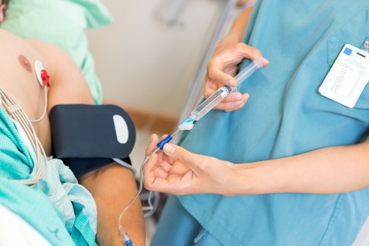 Registered Nurse (RN) starts an IV line then injects prescribed medication as part of her job duties.